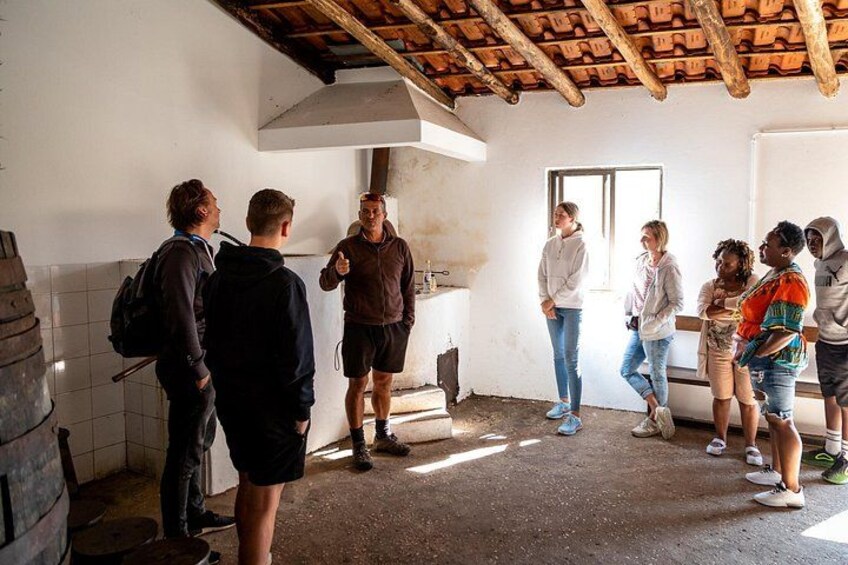 Un groupe de personnes se trouve dans une pièce rustique, dotée d’un sol carrelé, d’un plafond en bois et d’un tableau blanc accroché au mur. 3