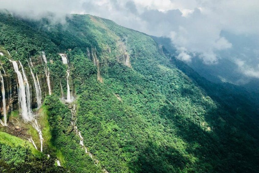 A mountainous landscape with multiple waterfalls cascading down the slopes. 3