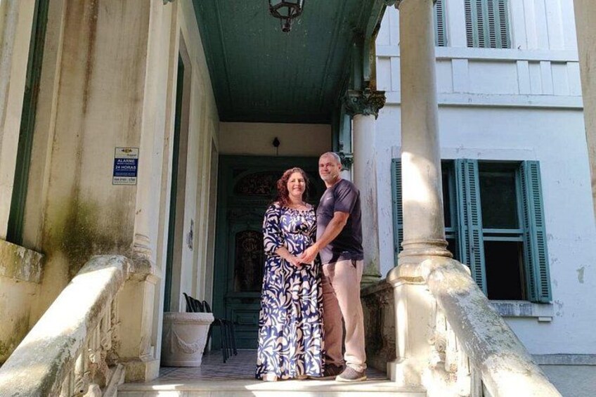 A couple standing on a stone staircase with a building in the background. 3