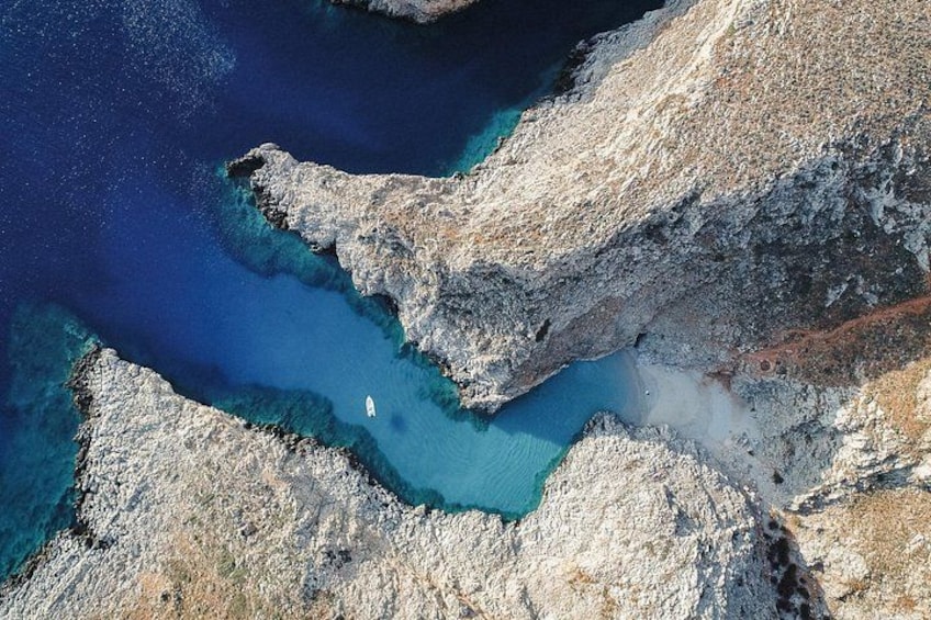 A rugged coastline with clear blue waters and rocky terrain. 1