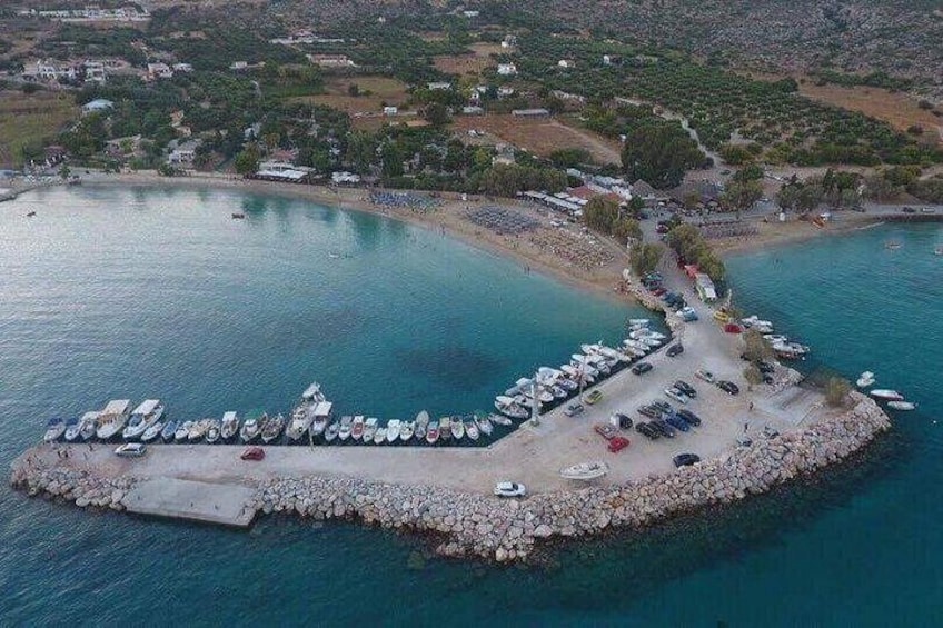An aerial view of a coastal area with a marina, boats, and a rocky breakwater. 2