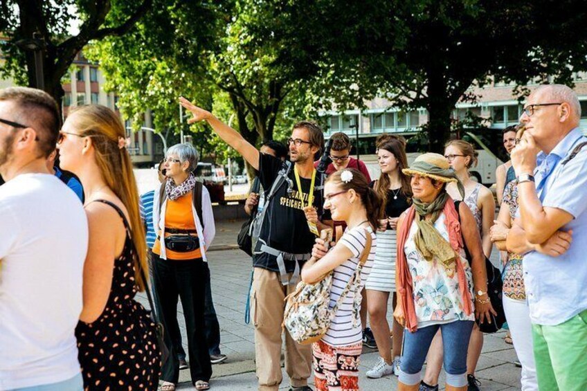 A group of people standing outdoors, some pointing in different directions. 4