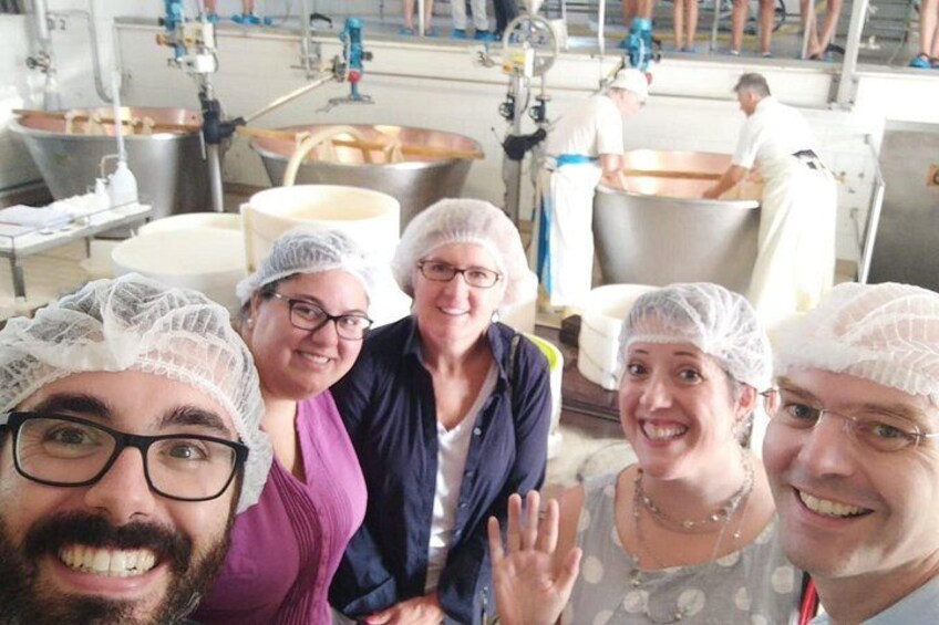 A group of people in a kitchen setting with stainless steel appliances and a large industrial sink. 2