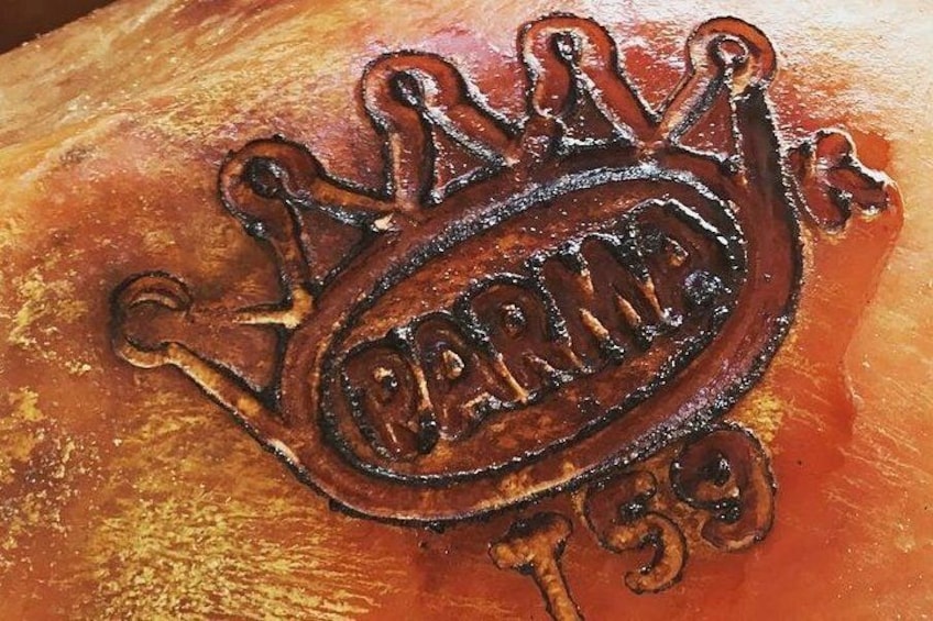 A wooden surface with a carved emblem featuring a crown and the text 'PARIS 139'. 2