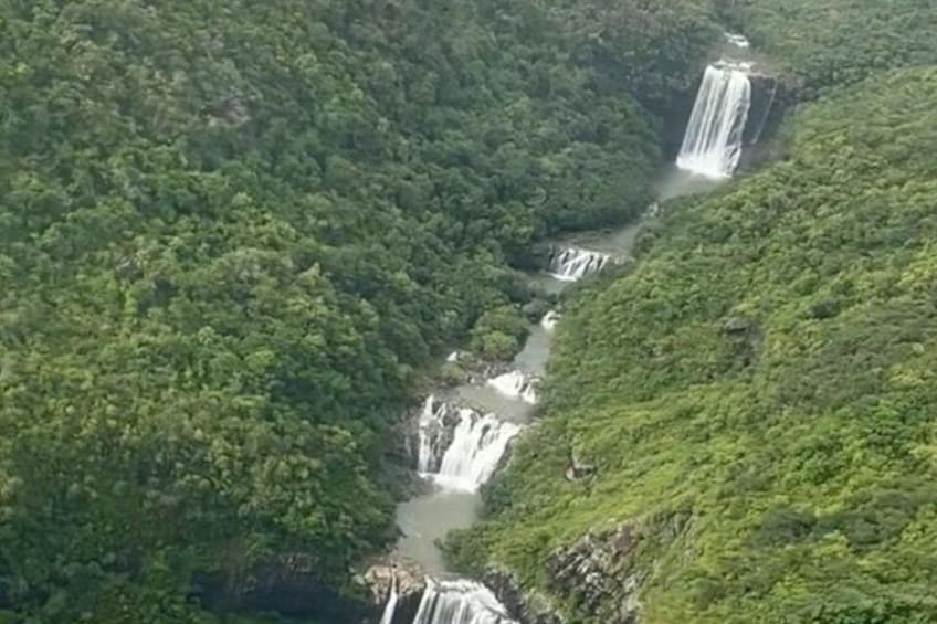 Una cascada fluye por un exuberante valle verde. 2