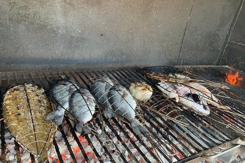 Du poisson grillé sur un barbecue, avec un feu qui crépite en arrière-plan. 3