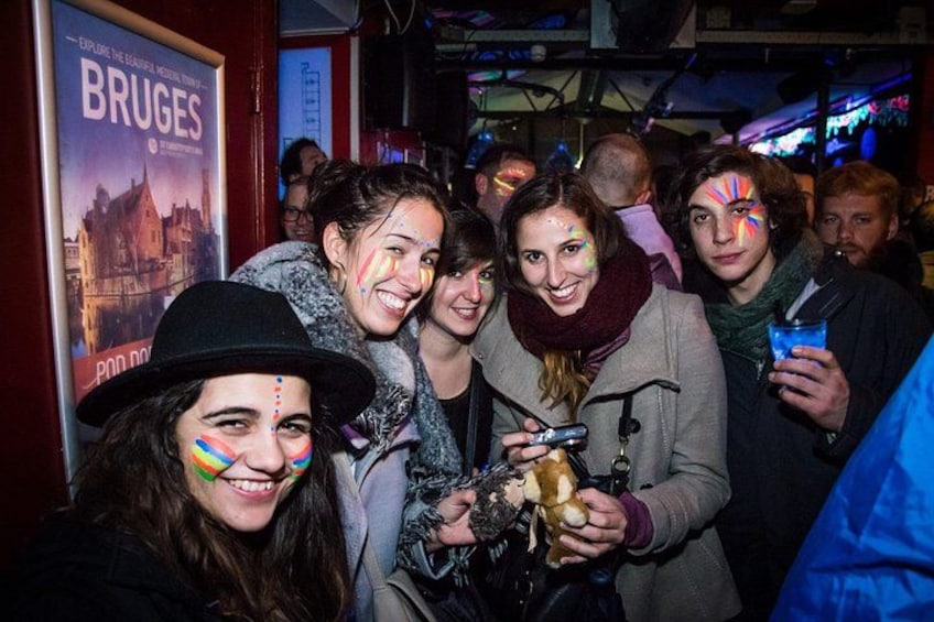 A group of people at a social event, some holding drinks and one holding a trophy. 2