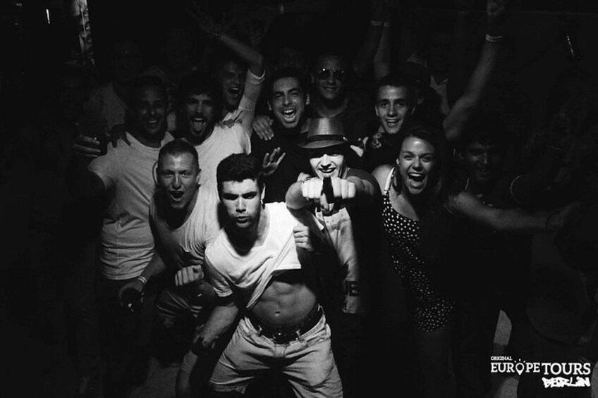 A group of people in a dimly lit setting, possibly a club or party environment. 3