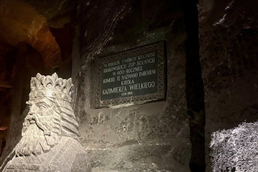 A stone relief and a plaque with text in a cave. 1