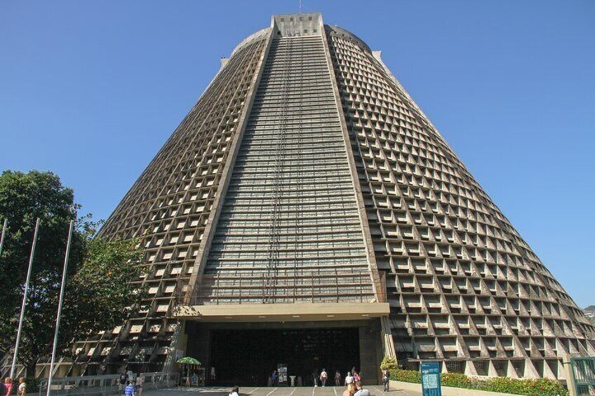 A tall, pyramid-shaped building with a grid-like facade and a large entrance. 2