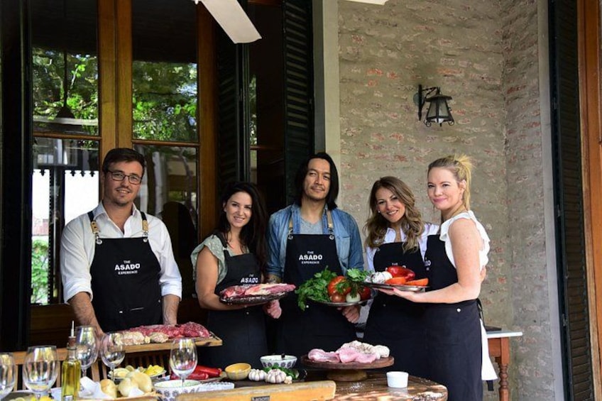 Un grupo de personas con delantales en una cocina, con alimentos y vasos sobre la encimera. 3