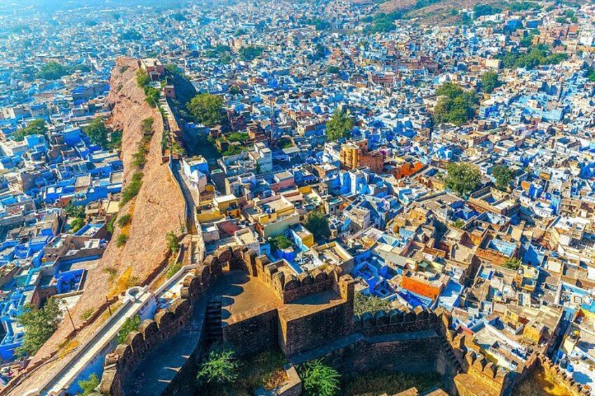 Un paisaje urbano con una fortaleza destacada y edificios de techos azules. 1