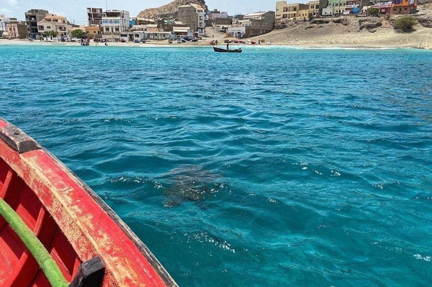 A coastal town with buildings, a beach, and a boat in the water. 5