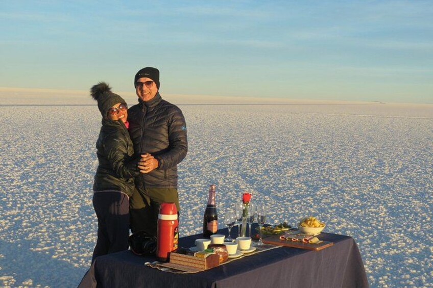 Een stel staat op een met sneeuw bedekt veld, met een gedekte tafel op de voorgrond. 2