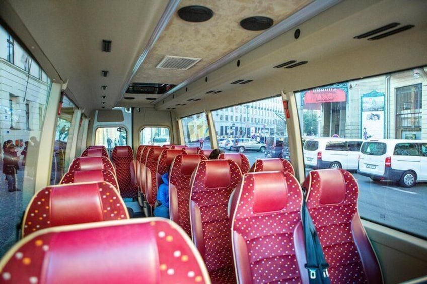 The interior of a bus with red seats and a window view of the street outside. 2