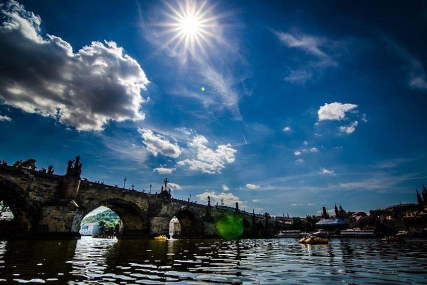 A river with a bridge, a boat, and a clear sky. 1