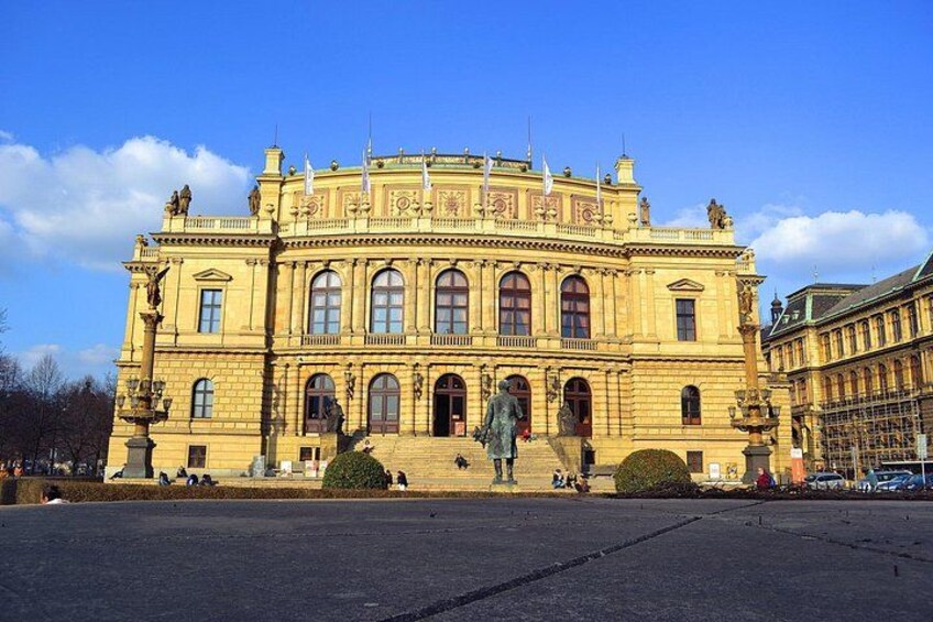 A large, ornate building with a symmetrical facade, arched windows, and statues at the entrance. 2