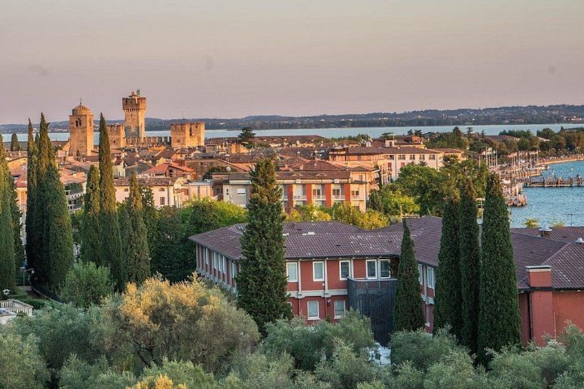 Paesaggio costiero con torri storiche, edifici residenziali e un porto turistico. 5