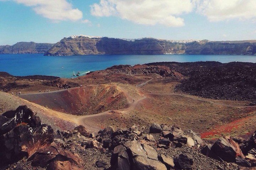 A volcanic landscape with a crater, a road, and a body of water in the background. 3