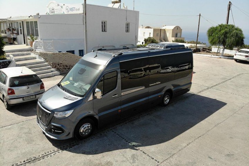 A silver van parked in a lot with a building in the background. 2