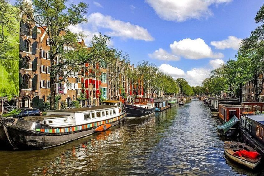 Un canal con barcos, edificios y árboles. 1