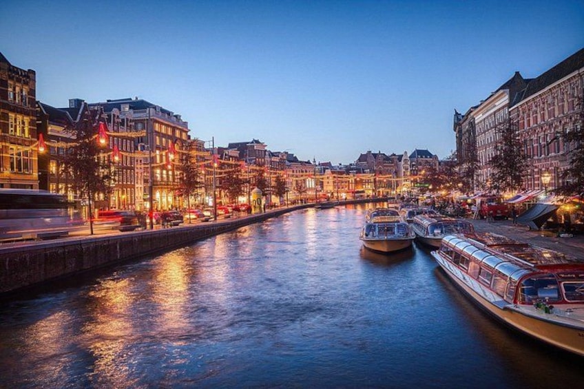 Un río con barcos, edificios iluminados y un puente. 4