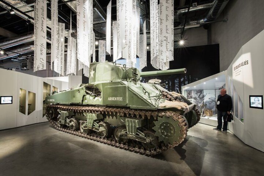Un vehículo blindado verde con la etiqueta 'ARSENITE' en un museo. 2