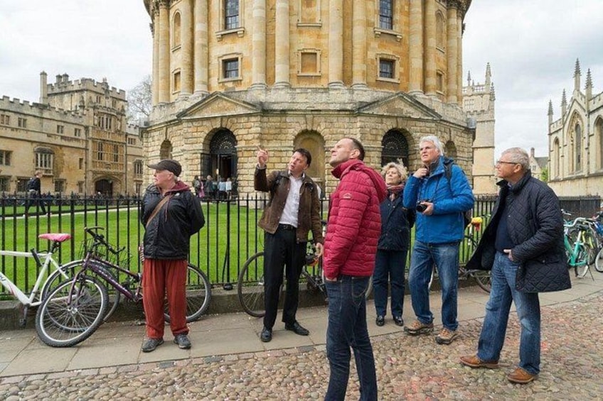 A group of people standing in front of a historic building with a large arched entrance. 3