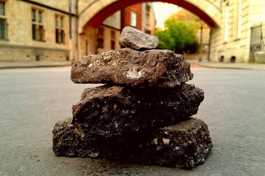 A stack of rocks on a street with a building in the background. 5
