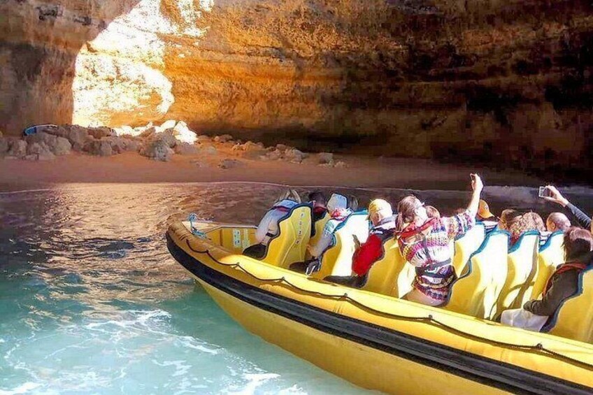 A yellow boat with passengers on a calm body of water, surrounded by rocky cliffs. 3