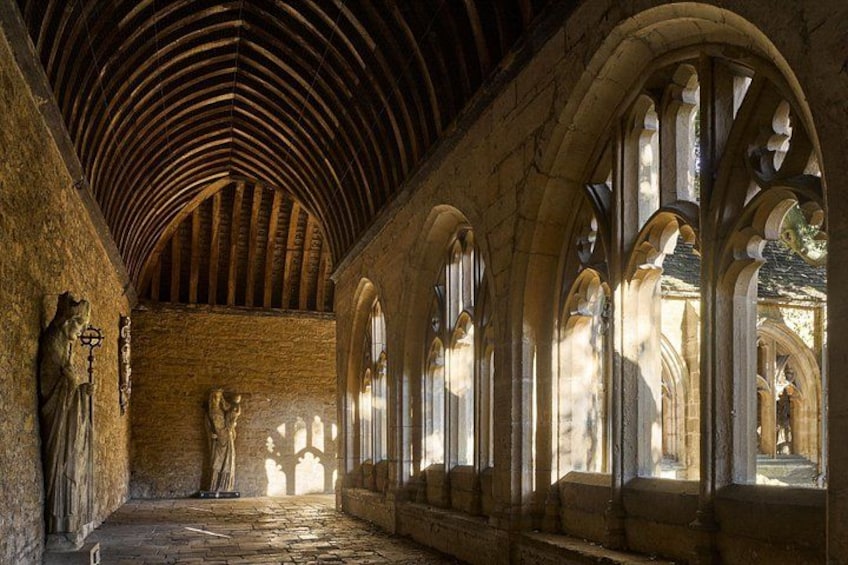 An interior with arched windows, stone walls, and a vaulted ceiling. 1