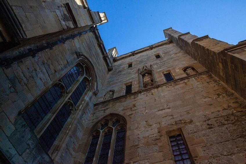 A historic stone building with arched windows and a clear blue sky. 3