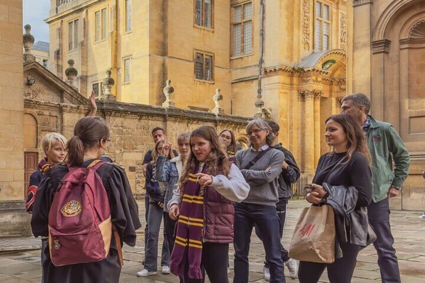 A group of people standing in front of a historic building with classical architecture. 5