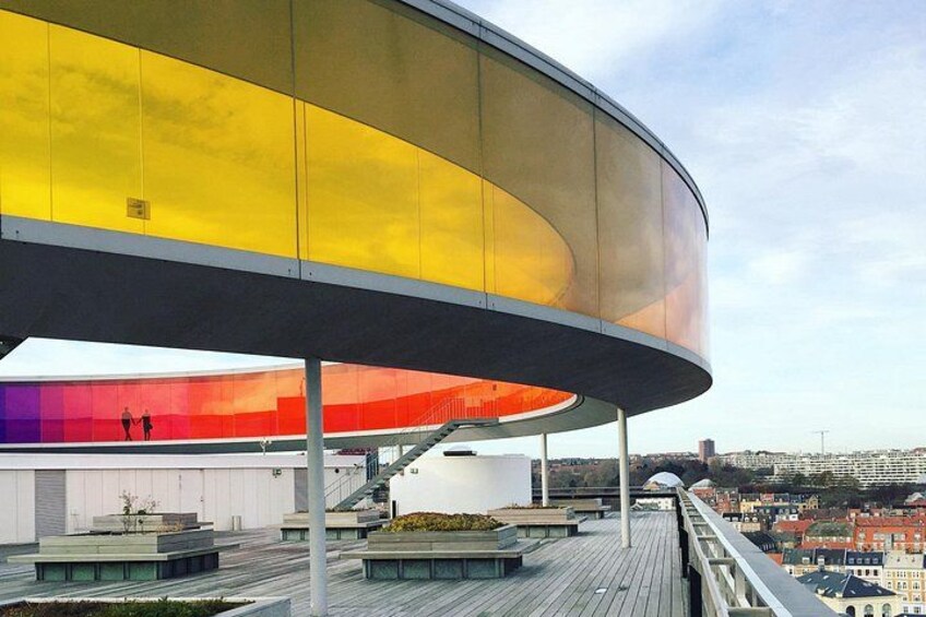 En moderne bygning med buet tag og en reflekterende overflade. 4