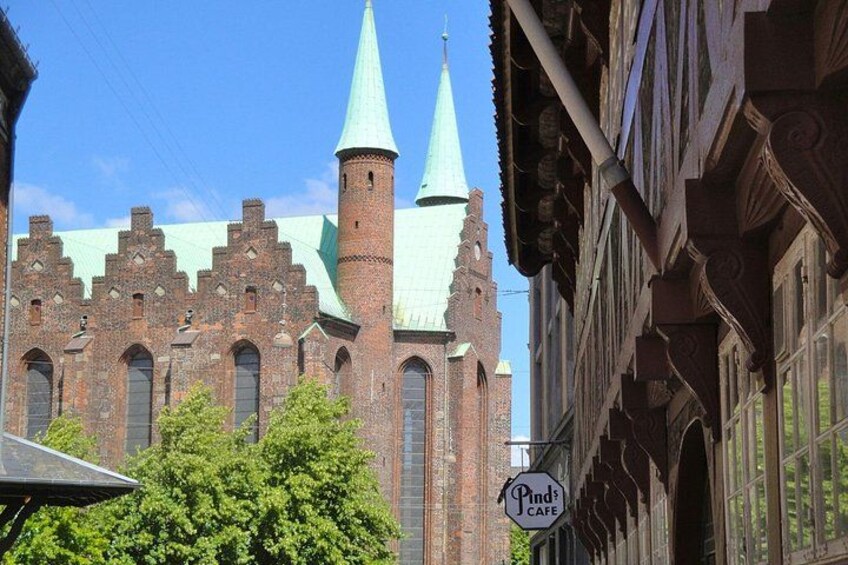 En historisk kirke med to tårne og et skilt med café. 3