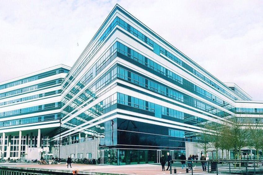 A modern glass building with multiple floors and a reflective facade. 5