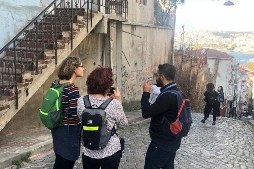Des personnes qui marchent sur une rue pavée, un escalier et un bâtiment couvert de graffitis. 4
