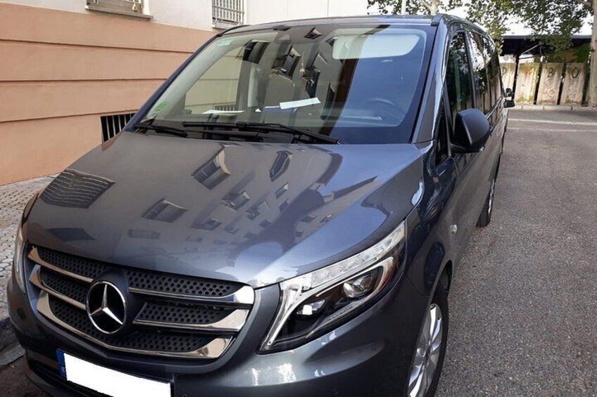 Un SUV de color oscuro estacionado sobre una superficie pavimentada. 3