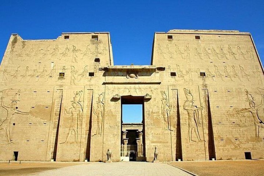 A large ancient Egyptian temple with hieroglyphs and statues. 1