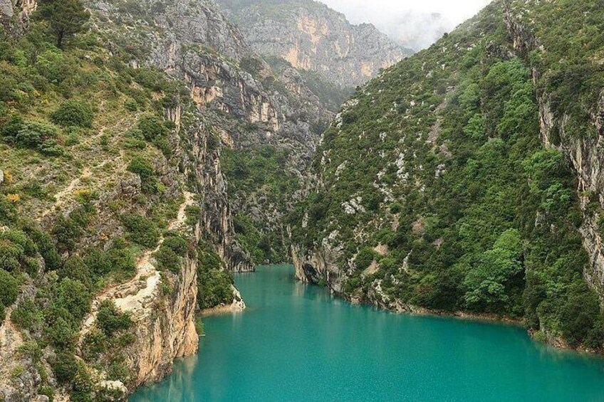 A turquoise river winding through a mountainous landscape with dense green vegetation. 4