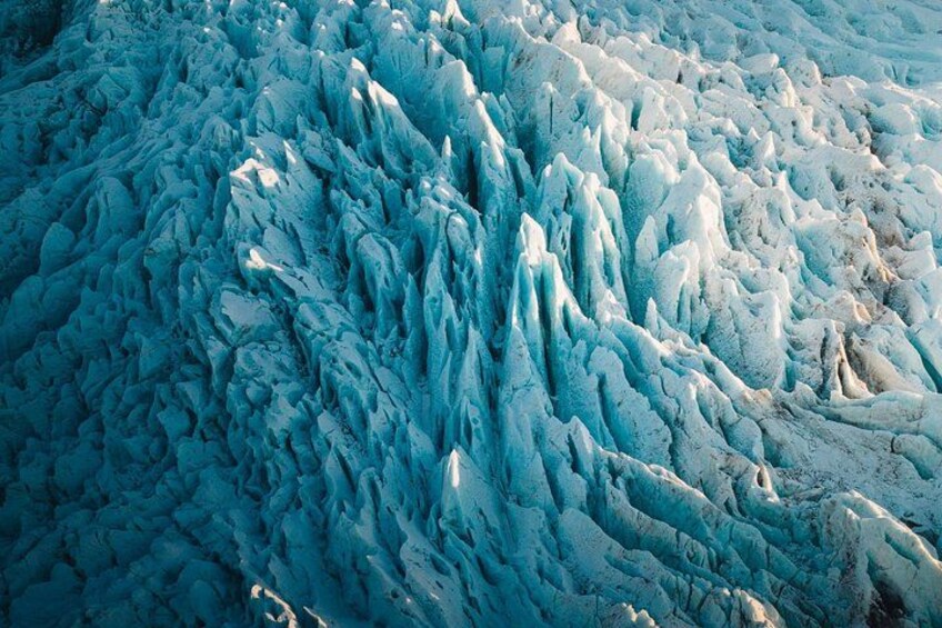 A glacier with intricate ice formations and crevasses. 2