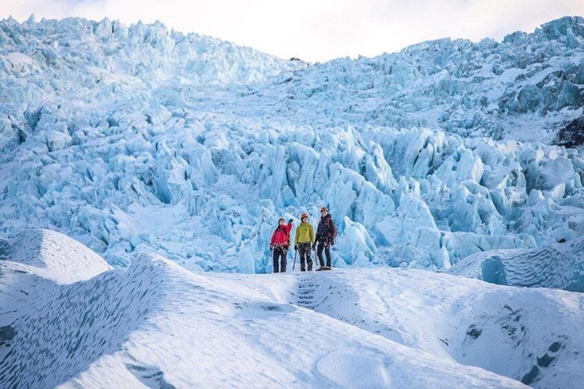 A glacier with people standing on its edge. 1