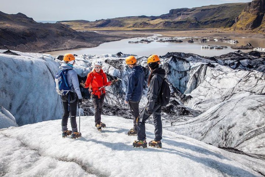 A group of people on a glacier with a lake in the background. 1