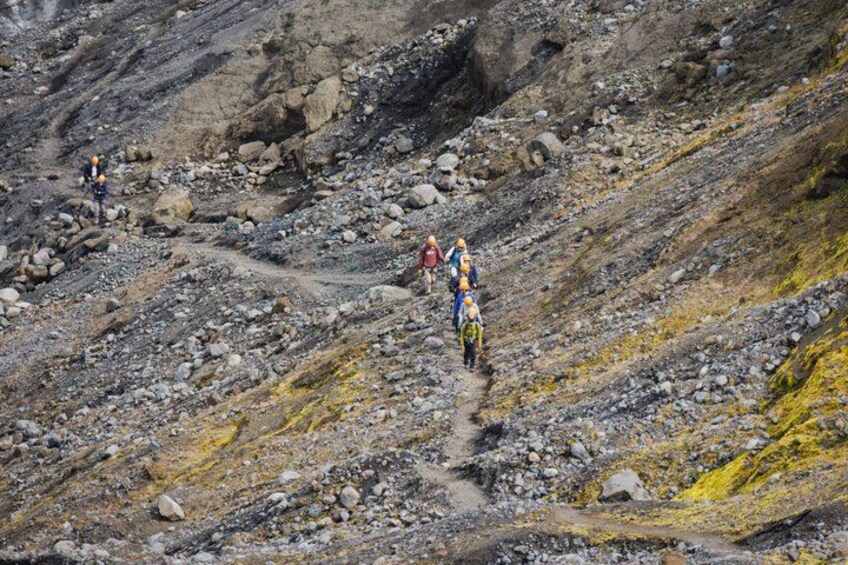 A rugged mountainous terrain with rocky paths and hikers. 2