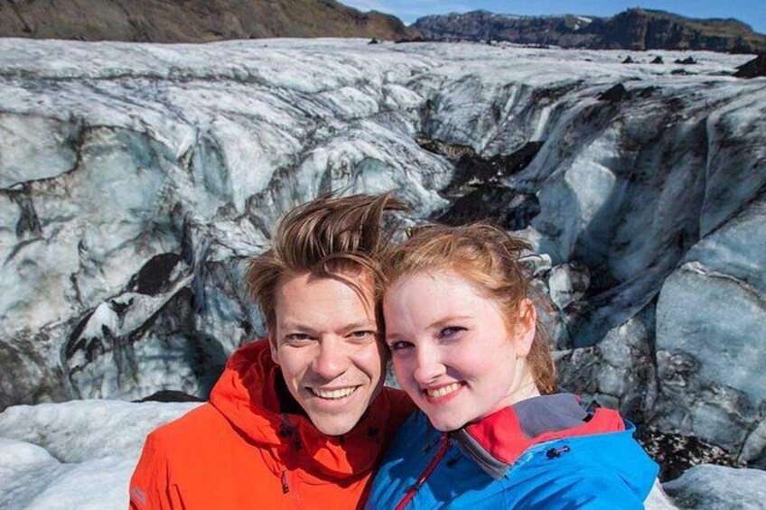 A glacier with ice formations and a person in a red jacket. 5