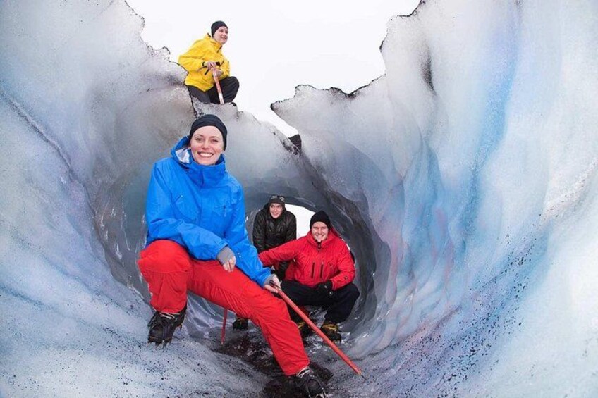 A group of people sitting inside a glacier cave. 2