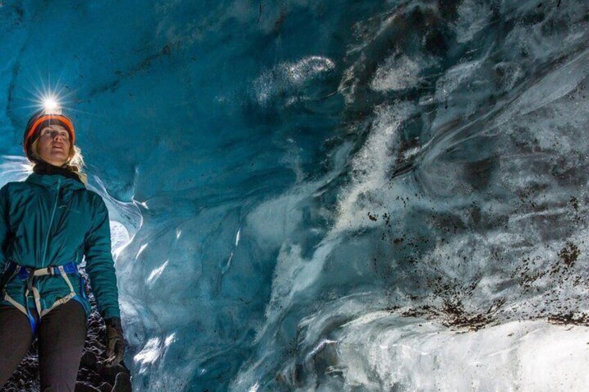 Una persona escala una formación de hielo con una linterna frontal. 1