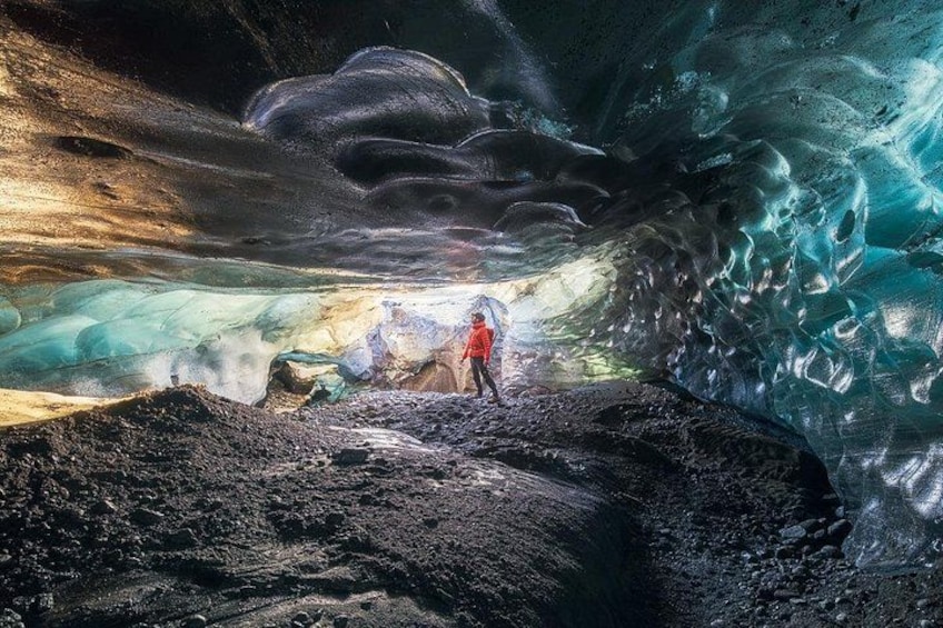 Una persona parada en una cueva con formaciones de hielo. 2