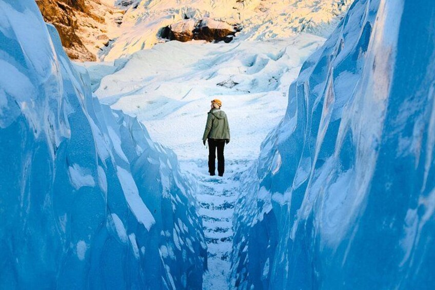 Una persona permanece de pie en un estrecho pasaje cubierto de nieve y hielo. 3