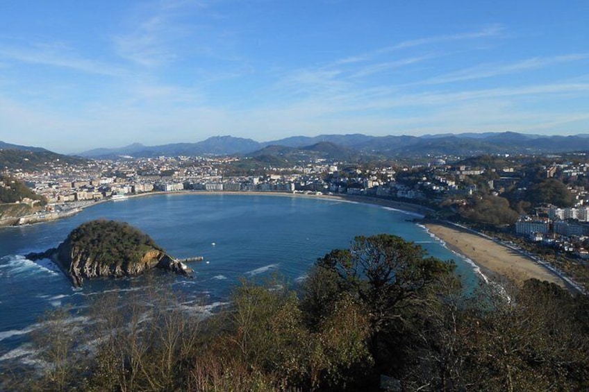 A coastal town with a bay, a small island, and a beach. 5
